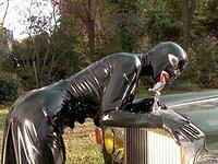 Latex Lucy licks a hood ornament and fucks her twat in a garden - movie 3 - 3