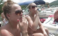 topless coeds have some fun in the sun on a boat join background